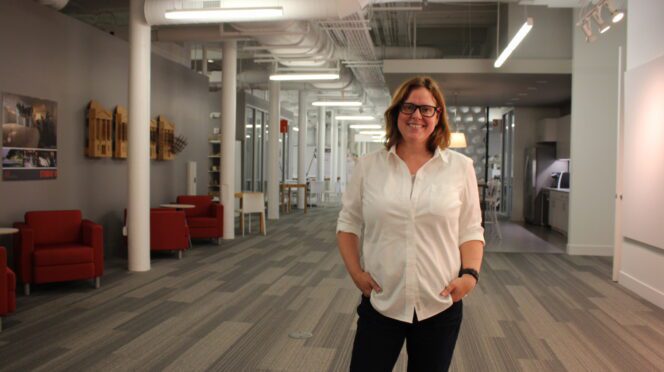 BD Wortham-Galvin stands in a long hallway and poses for a photo