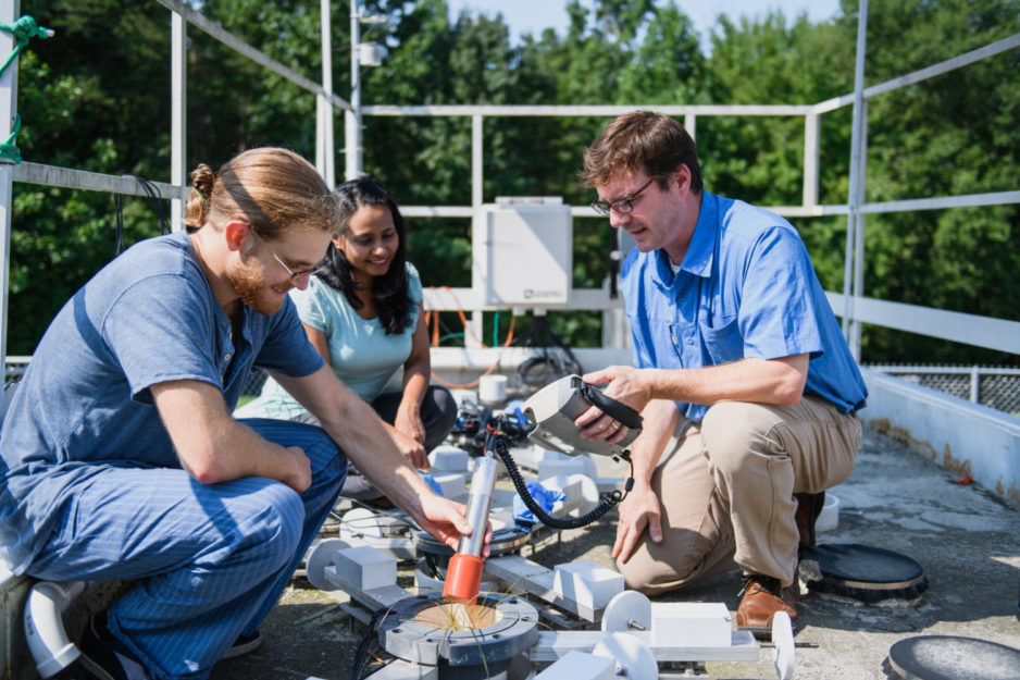 Brian Powell, right, works on a test bed that was developed for the team's research.