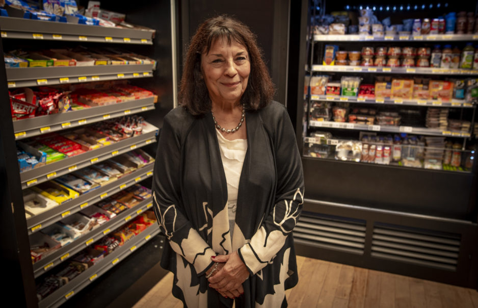 Aleda Roth stands in a P.O.D. store in Sirrine Hall with shelves of food on either side of her.