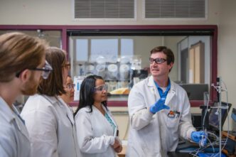 Brian Powell, right, works with students in his lab.