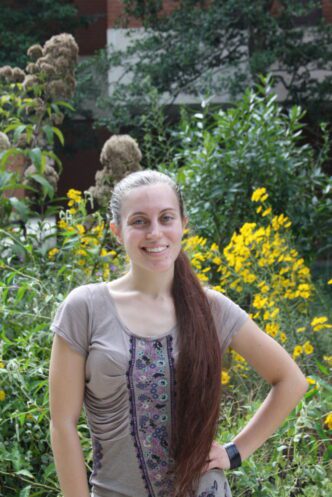Angelica Werth stands outside Clemson's sustainable garden in the agriculture quad.