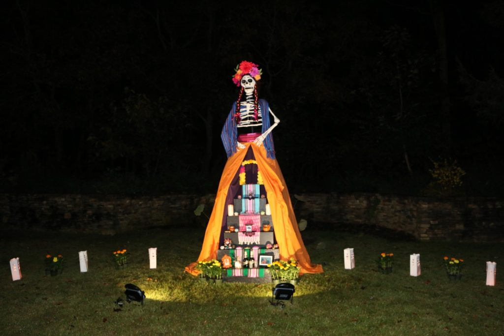 La Catrina, a popular icon of death in Mexico, presides over the altar at the Day of the Dead celebration.