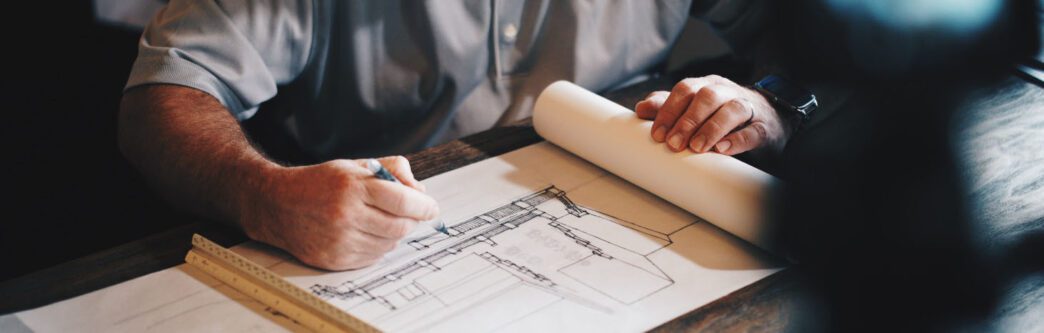 Image of hand drawing blueprint on white paper