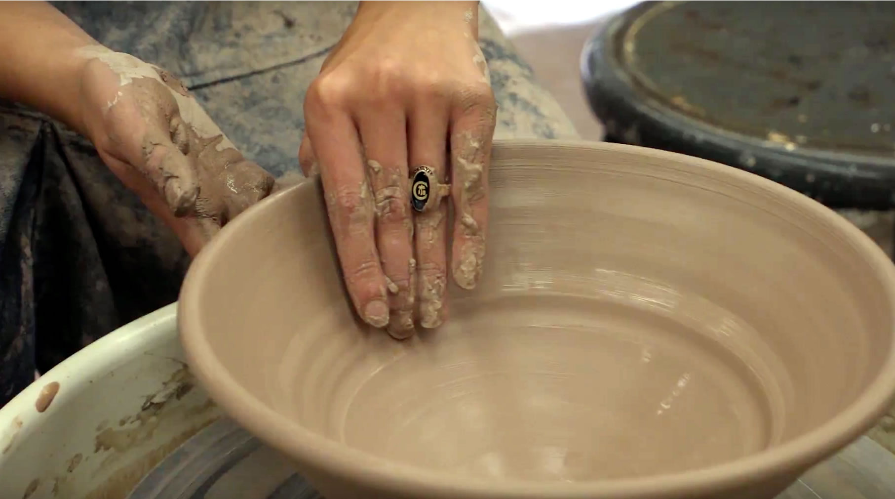 A student shapes a bowl in the studio.