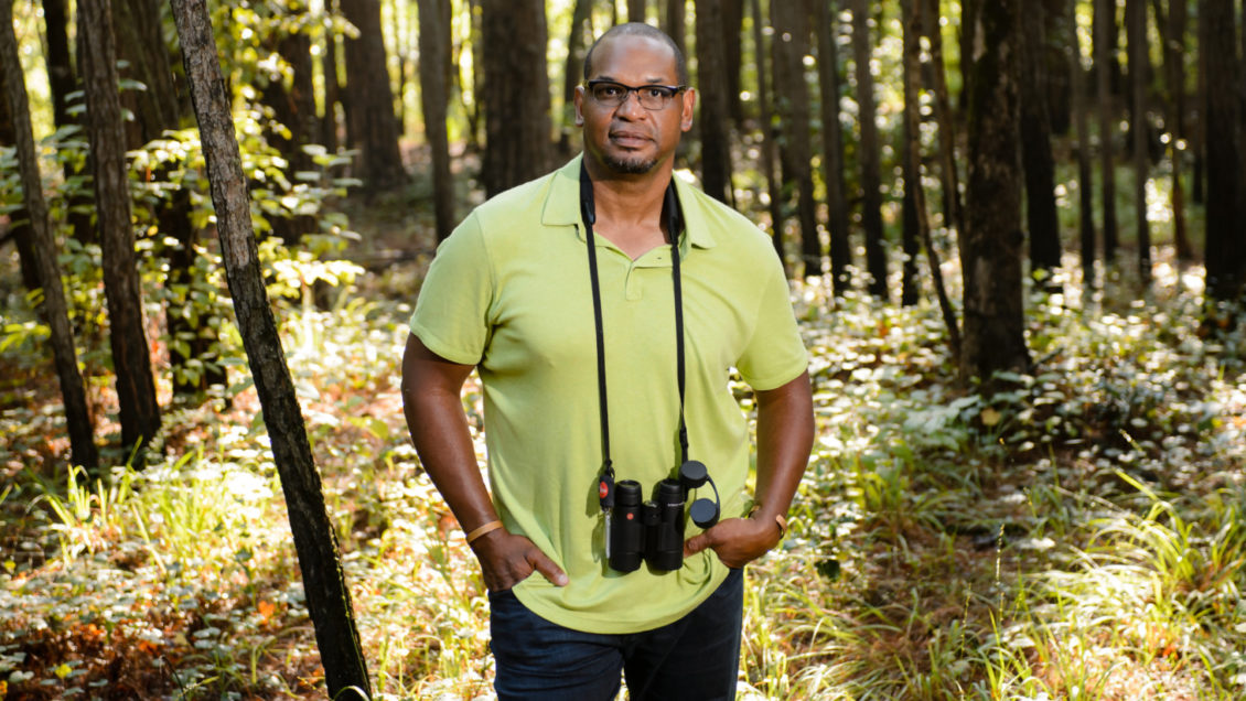 J. Drew Lanham with binoculars in the woods.