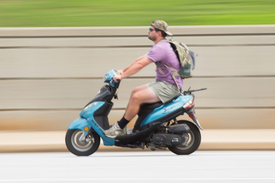 A Clemson student riding a moped on Walter T. Cox Boulevard.