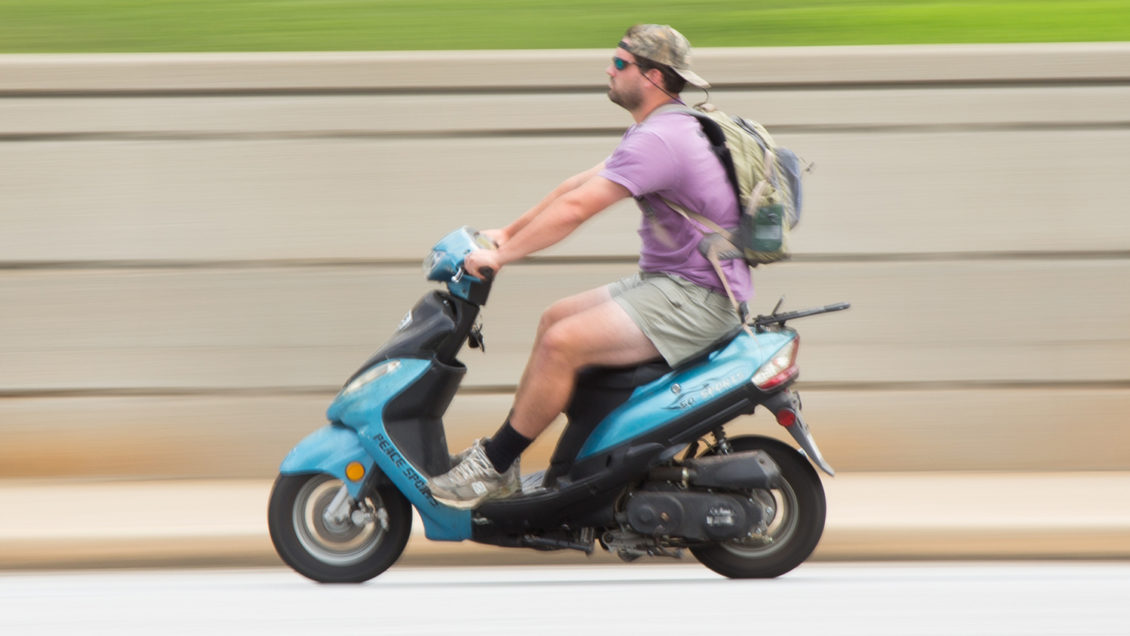 A Clemson student riding a moped on Walter T. Cox Boulevard.