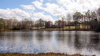 The main building at Sandhill REC is pictured from across the pond behind it.