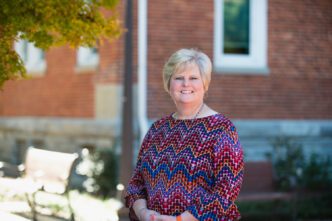 Susan Falendysz sits on a bench on campus.