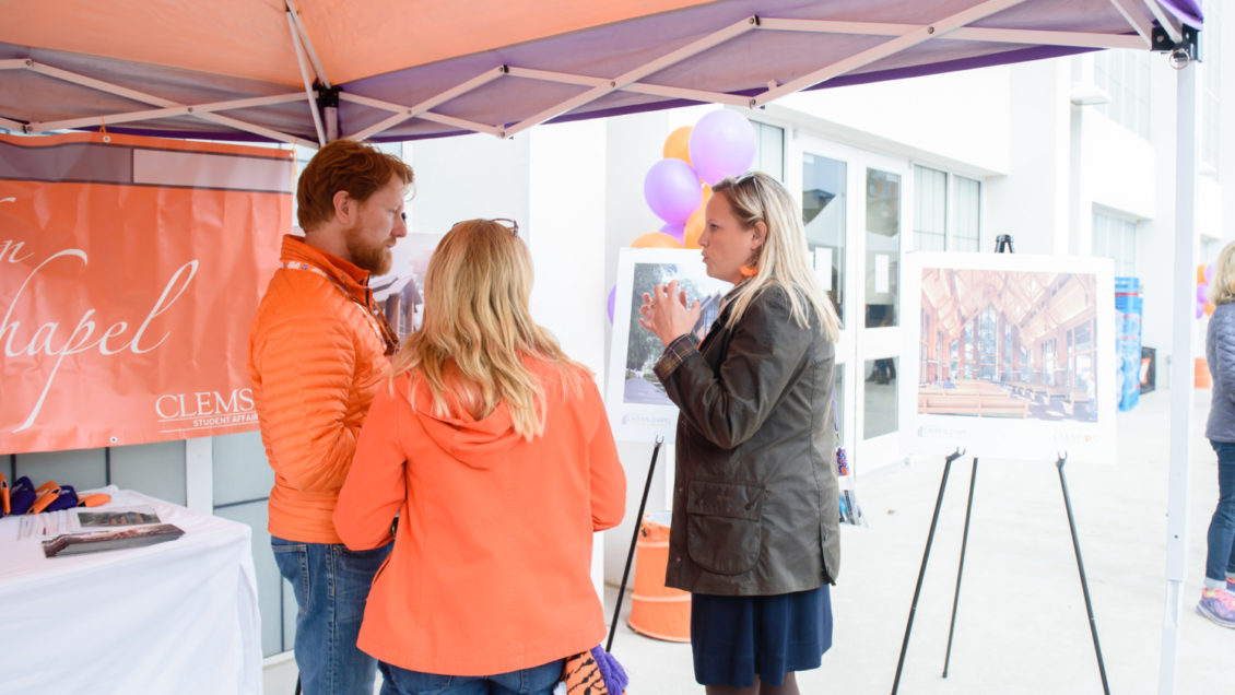 Brandy Page (right) discusses the Samuel J. Cadden Chapel with prospective donors at a 2018 tailgate prior to a Clemson football game.