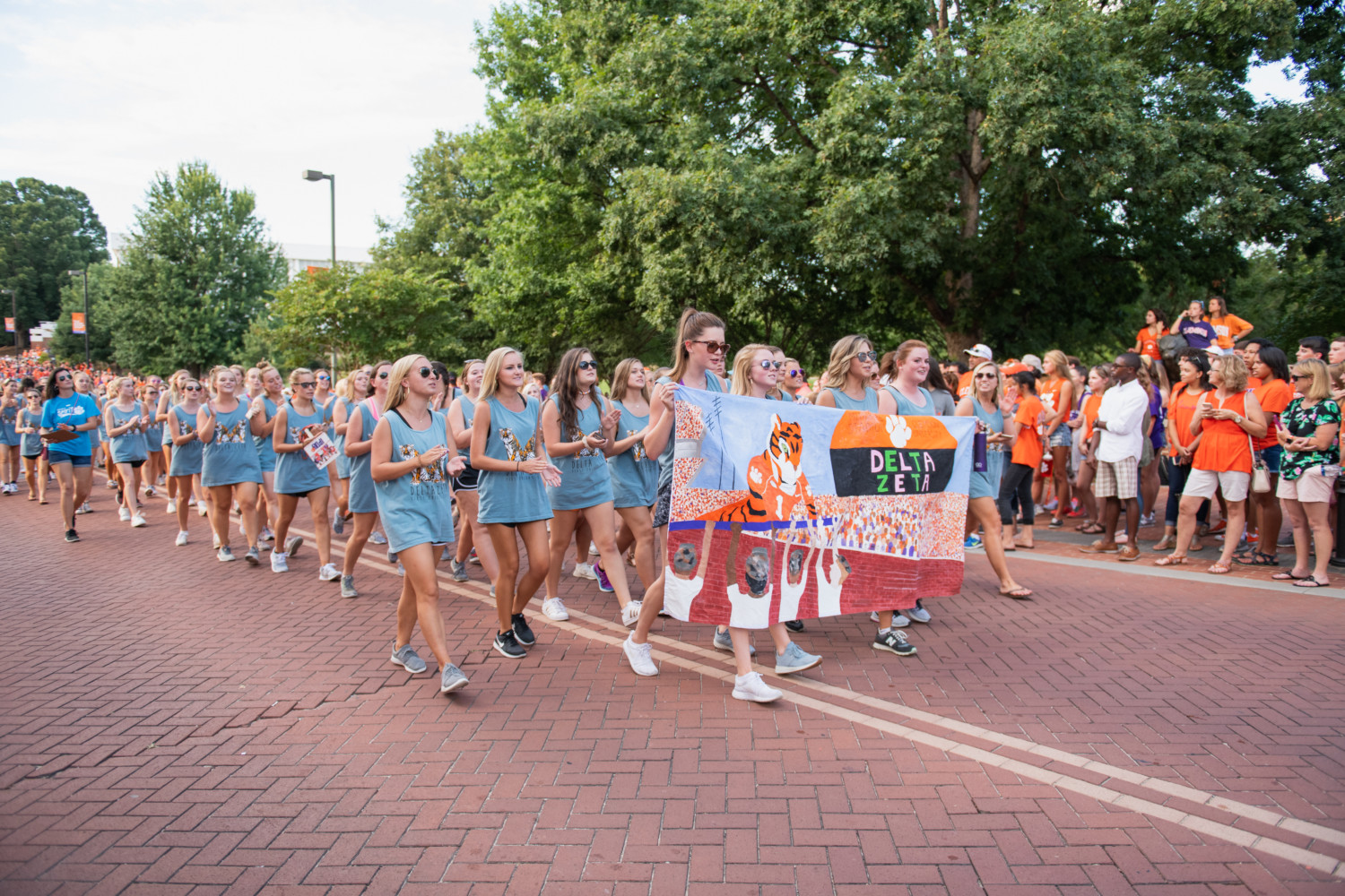 Members of Delta Zeta walk behind a banner during the 2018 First Friday Parade.