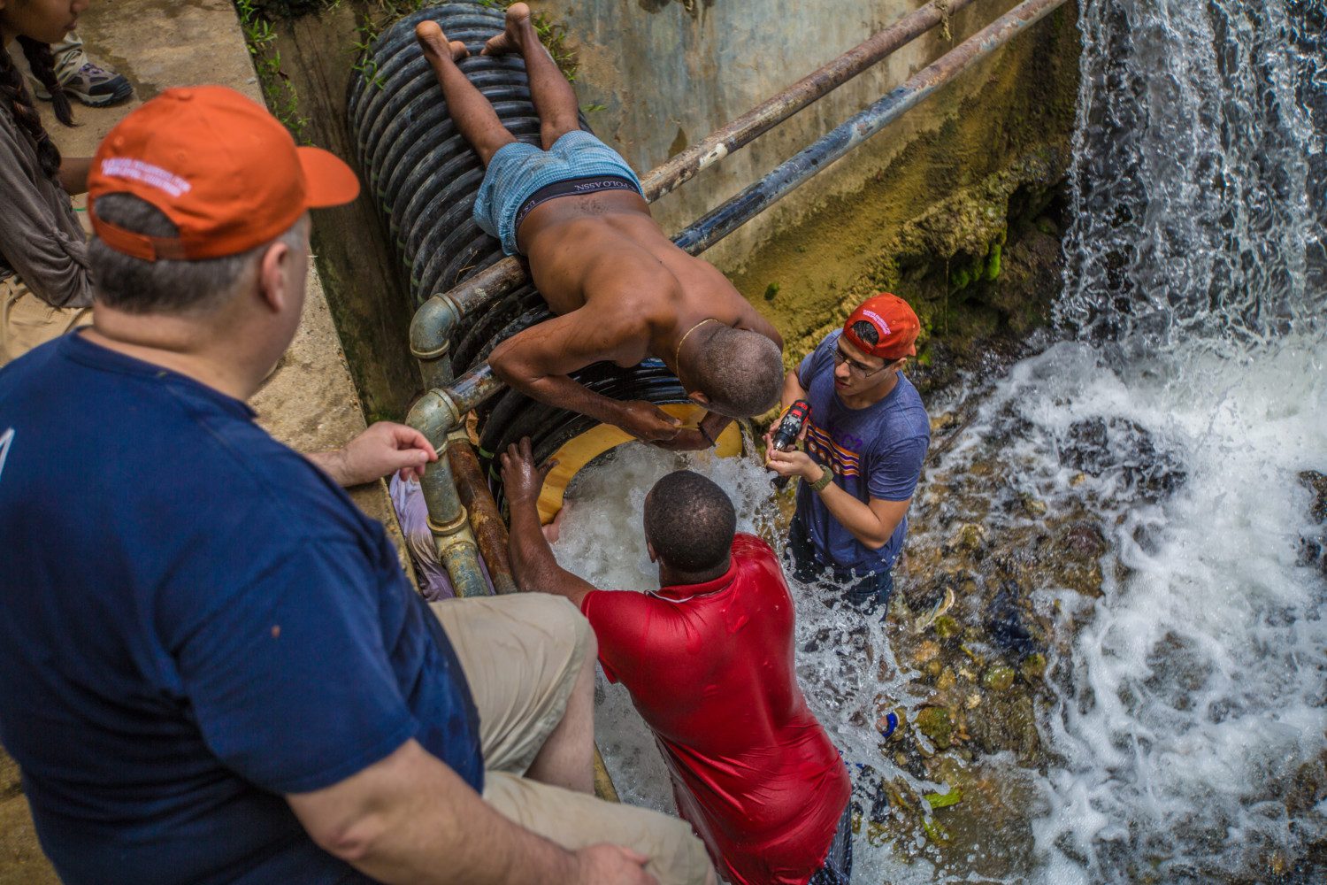 Clemson University students help provide clean water to Haitians. In this photo, the students stand in water while working on a pipe.