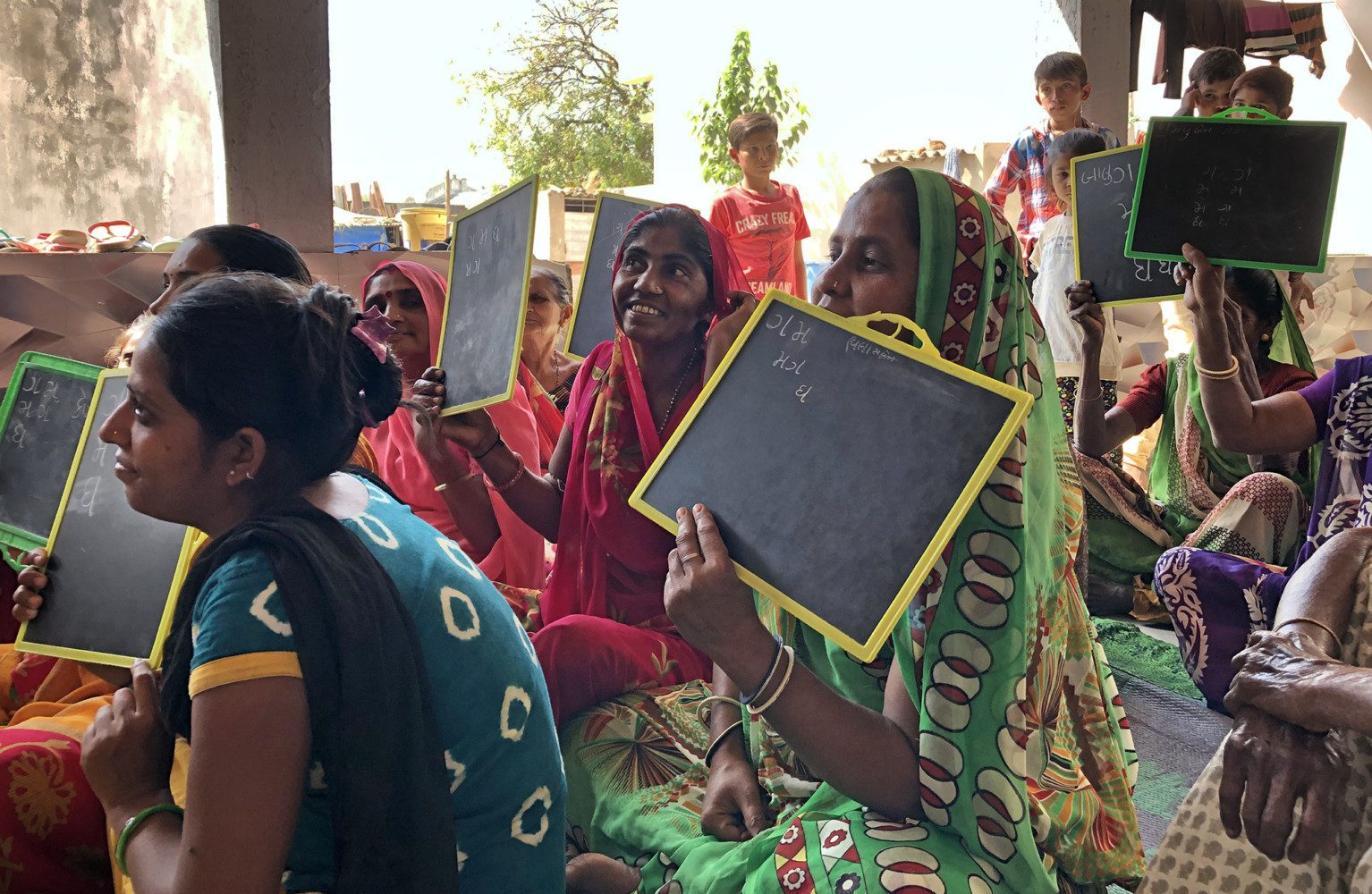 Women in India hold up small chalkboards
