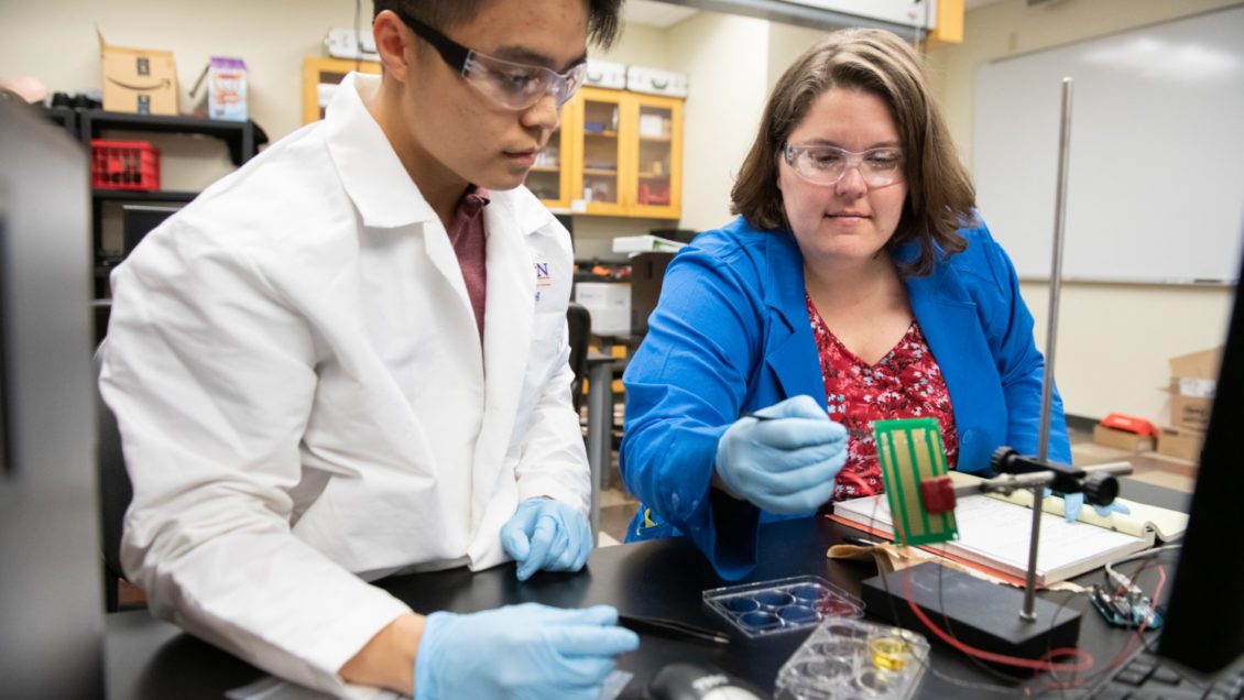 Melissa McCullough, right, works with rising senior Quan Lee on a urinalysis device she is developing as part of her Ph.D. studies.