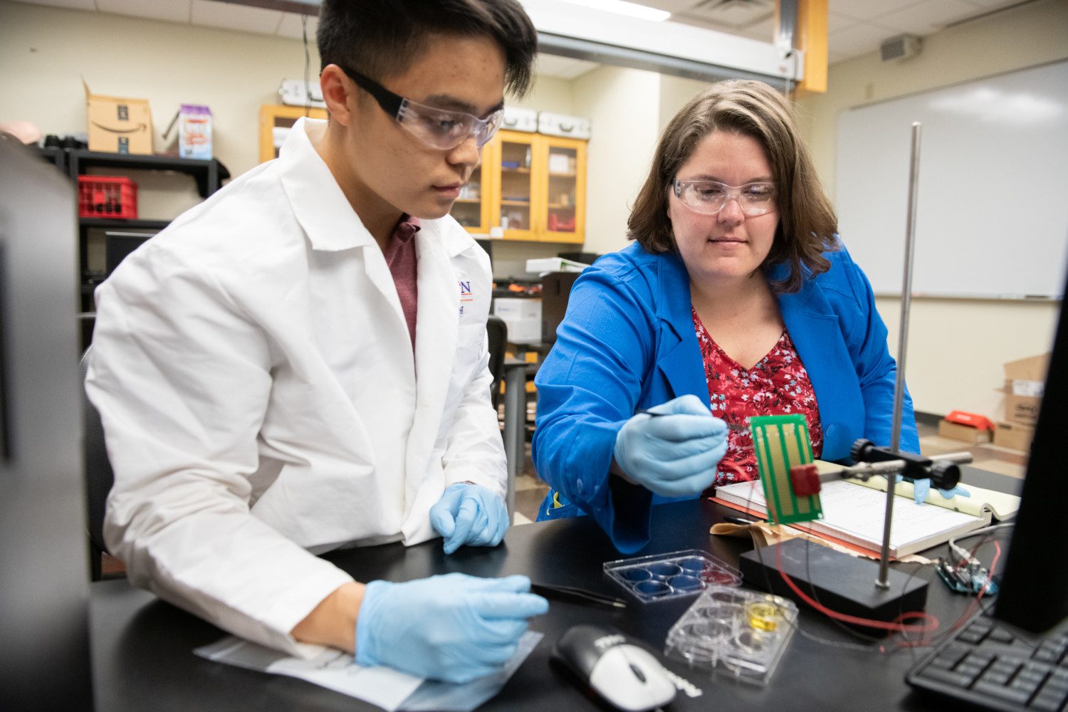 Melissa McCullough, right, works with rising senior Quan Lee on a urinalysis device she is developing as part of her Ph.D. studies.