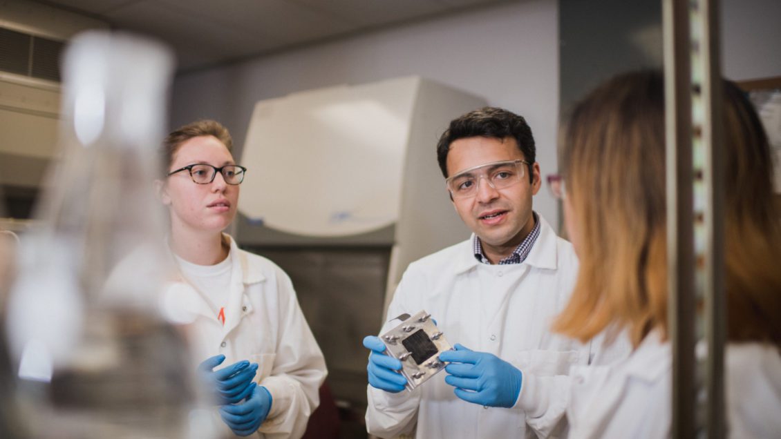 Sudeep Popat (center) holds a microbial fuel cell while working with his students at Clemson University's L.G. Rich Environmental Research Laboratory.