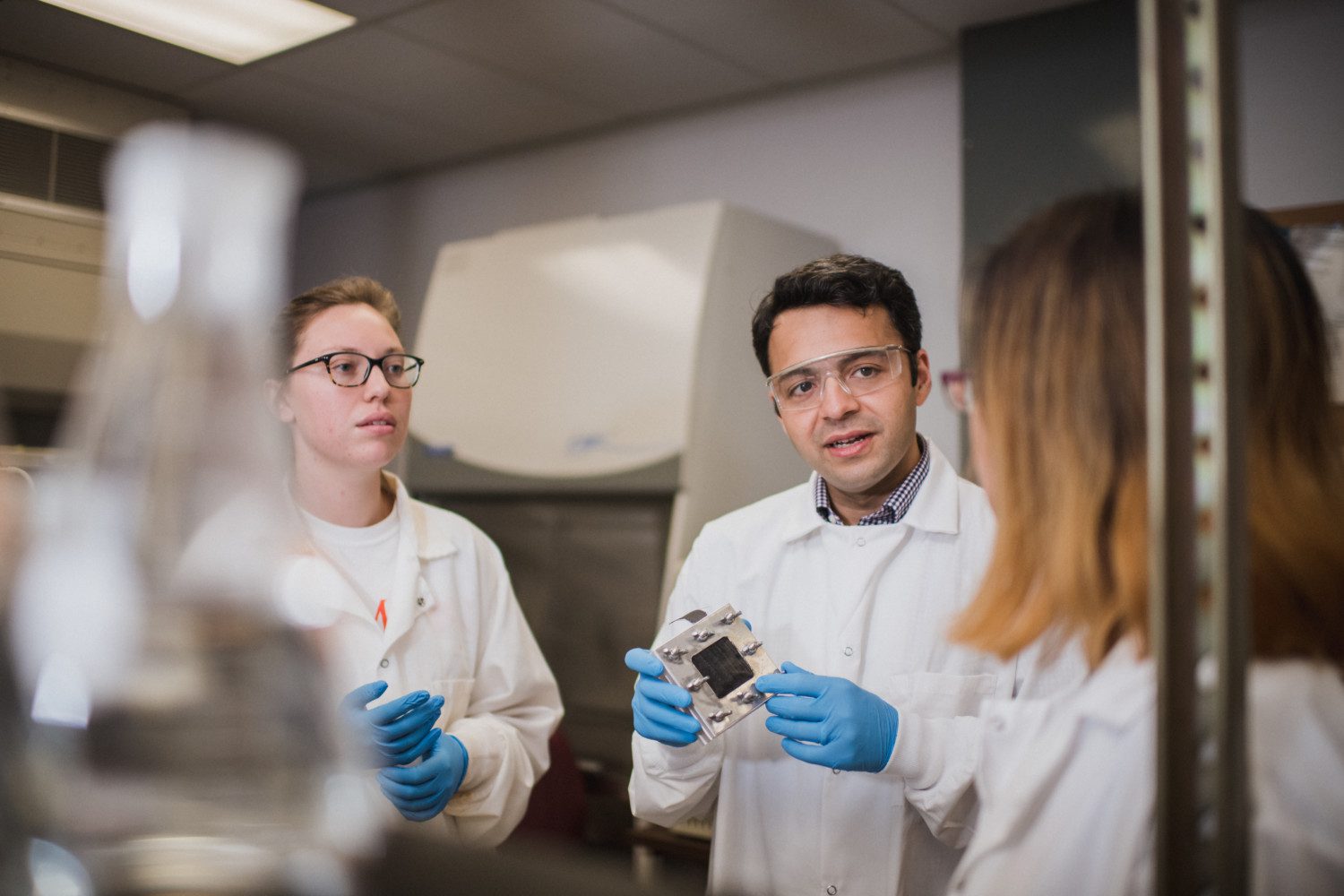 Sudeep Popat (center) holds a microbial fuel cell while working with his students at Clemson University's L.G. Rich Environmental Research Laboratory.