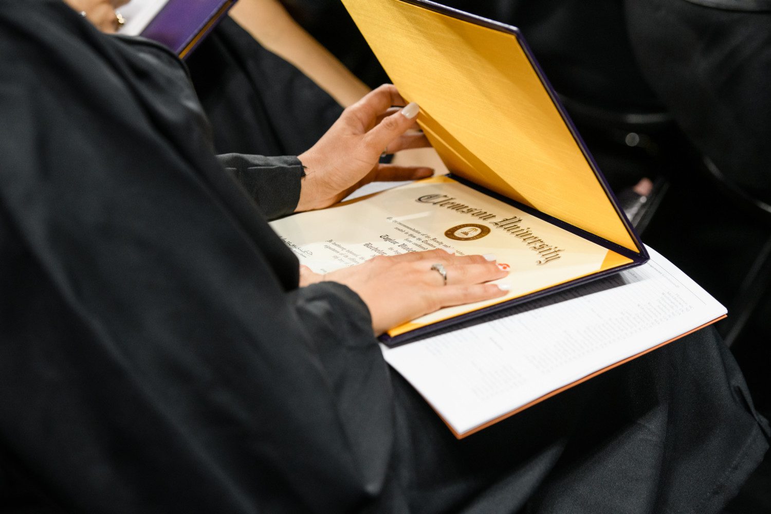 Photo of graduate looking at a diploma