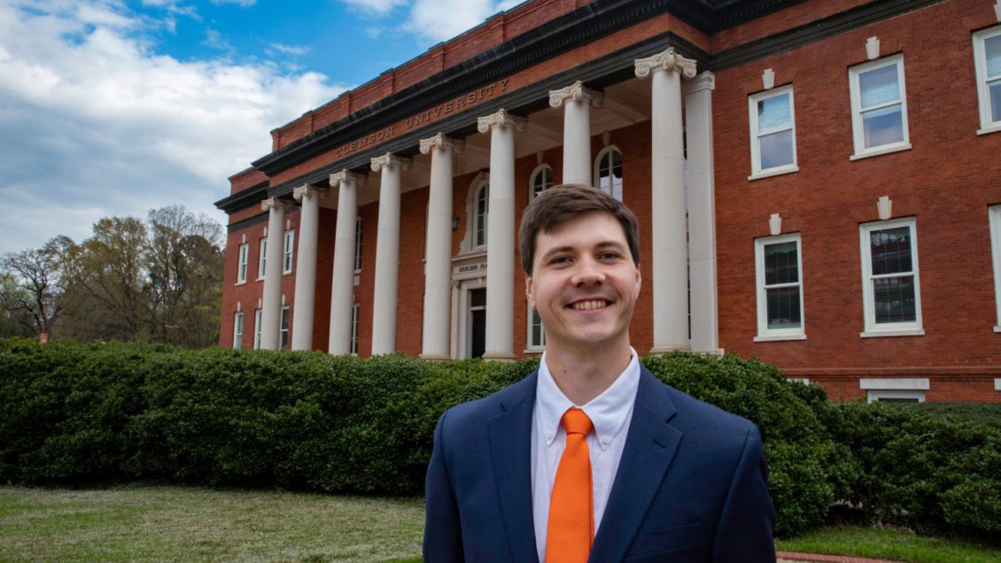 Graduate student government president Miles Maynard in front of Sikes Hall in 2019