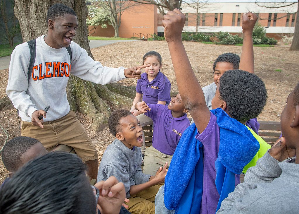 Clemson student plays a game with young students on tour of campus.