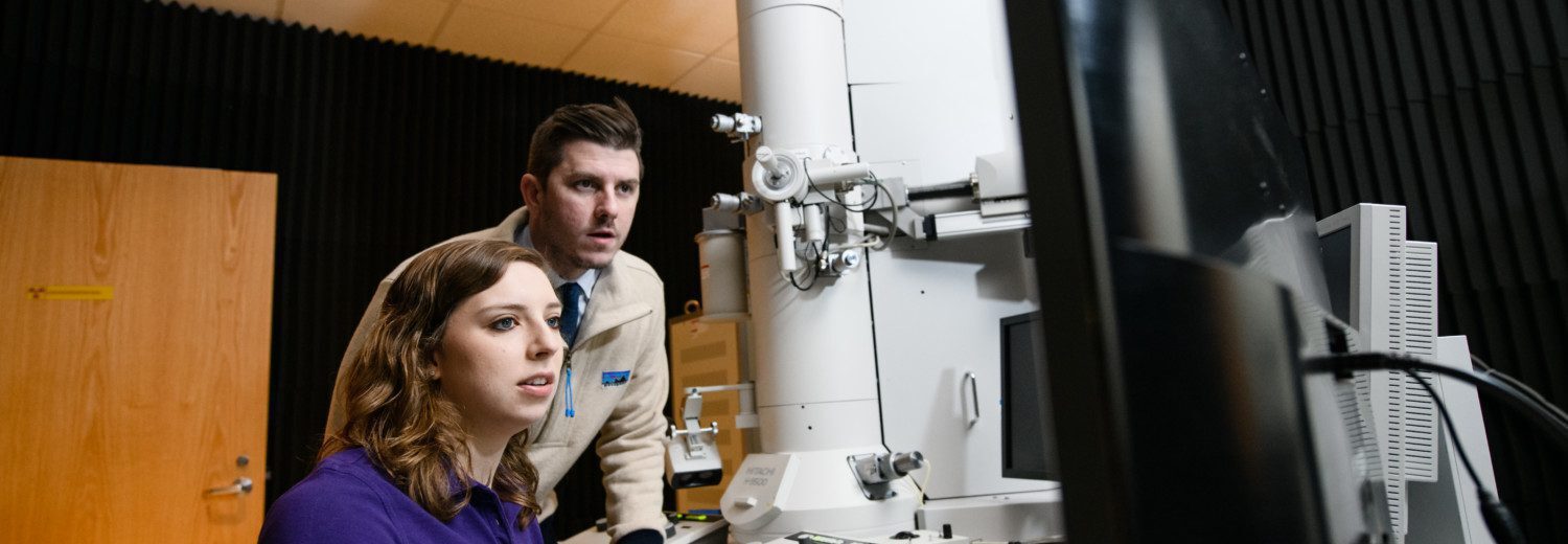 Clemson University Ph.D. student Allison Domhoff and Eric Davis, assistant professor of chemical and biomolecular engineering, use an electron microscope to analyze nanometer-sized particles.