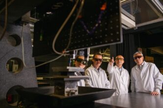 Members of Intelligent Systems for Extreme Environments discuss their work while gathered around a 3D printer that is enabling new research. They are (from left) Jane Zhao, associate professor of mechanical engineering; Jianhua “Joshua” Tong, an associate professor of materials science and engineering; Fei Peng, associate professor of materials science and engineering; and Hai Xiao, the Samuel Lewis Bell Distinguished Professor in Electrical Computer Engineering.