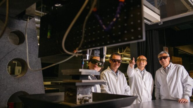 Members of Intelligent Systems for Extreme Environments discuss their work while gathered around a 3D printer that is enabling new research. They are (from left) Jane Zhao, associate professor of mechanical engineering; Jianhua “Joshua” Tong, an associate professor of materials science and engineering; Fei Peng, associate professor of materials science and engineering; and Hai Xiao, the Samuel Lewis Bell Distinguished Professor in Electrical Computer Engineering.