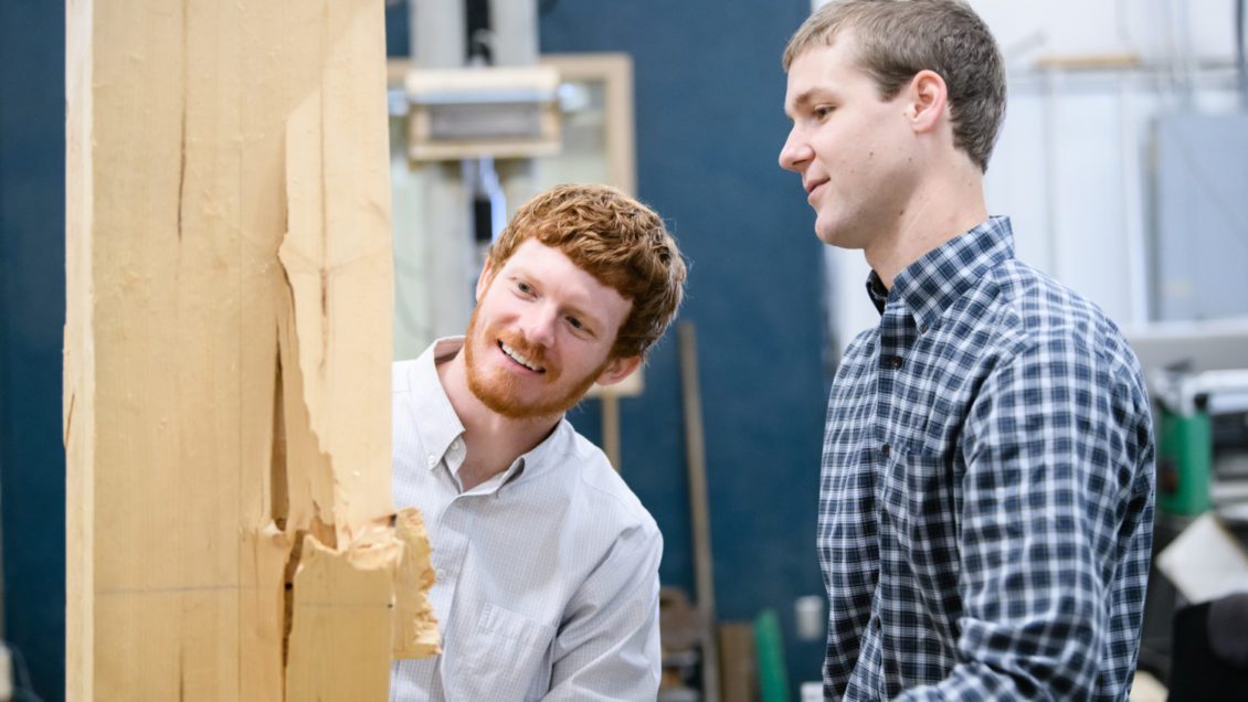 Graham Montgomery, left, and Michael Stoner examine a piece of wood that was put to the test in research at Clemson University.
