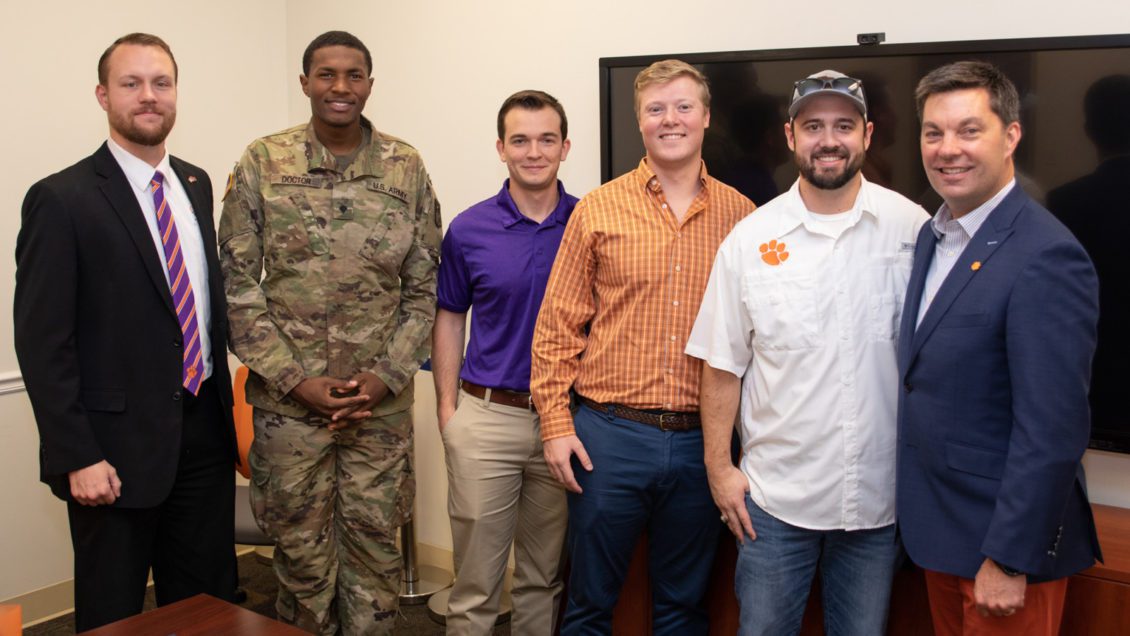 Photo of Brennan Beck (left), director of military and veteran engagement at Clemson, with Newport News Shipbuilding scholarship recipients Daquan Doctor, who serves in the Army National Guard; Damion Anderson, who served in the Marine Corps; Giff Finley, who served in the Coast Guard; and Stewart Fuller, who is on active duty with the Navy. At right is alumnus Matt Needy, who is the company’s vice president of operations.
