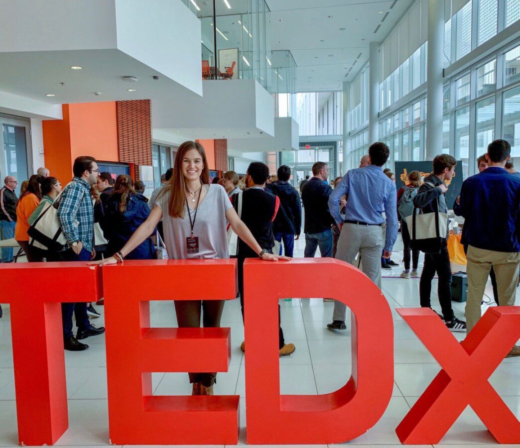 Addie Stone poses with signage from the TEDx Talk Series