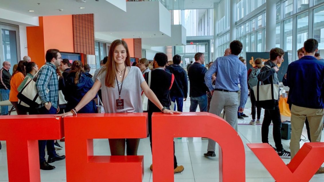 Addie Stone poses with signage from the TEDx Talk Series
