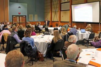 Clemson agribusiness expert addresses crowd at outlook conference.