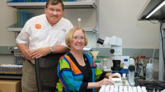 Anholt standing, Mackay sitting in lab