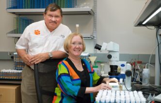 Anholt standing, Mackay sitting in lab