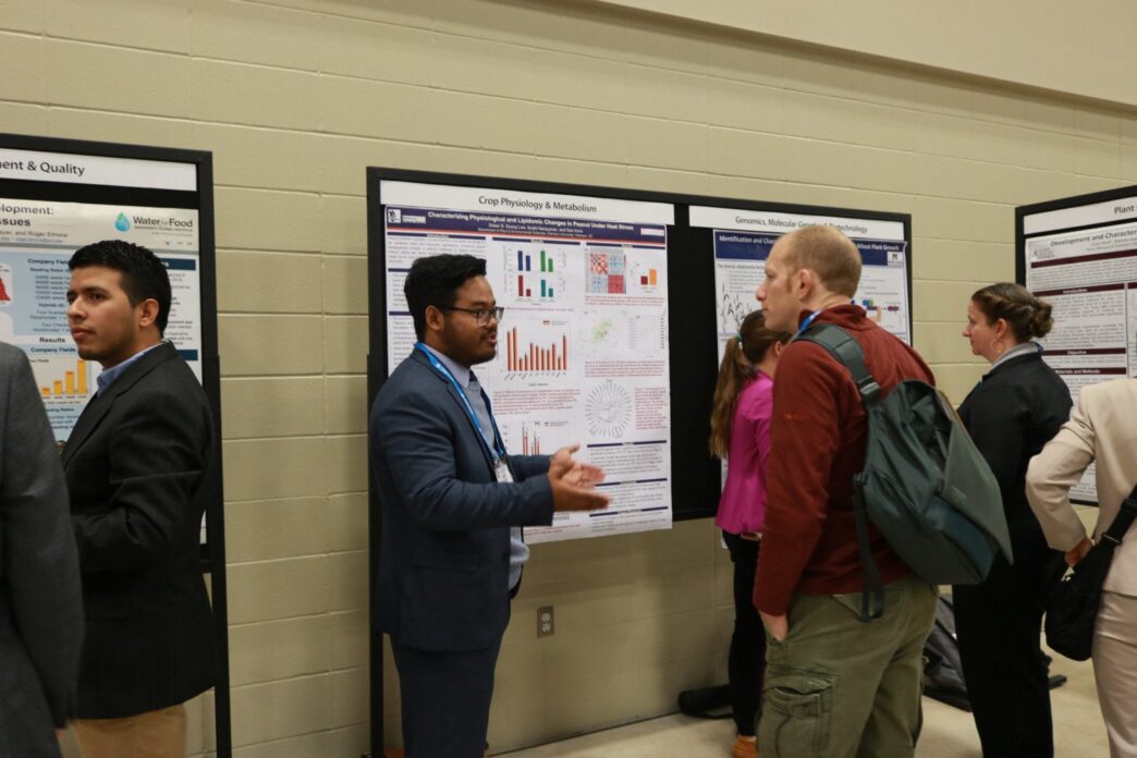 Zolian Zoong Lwe presenting his research to visitors at the international crop science meeting.