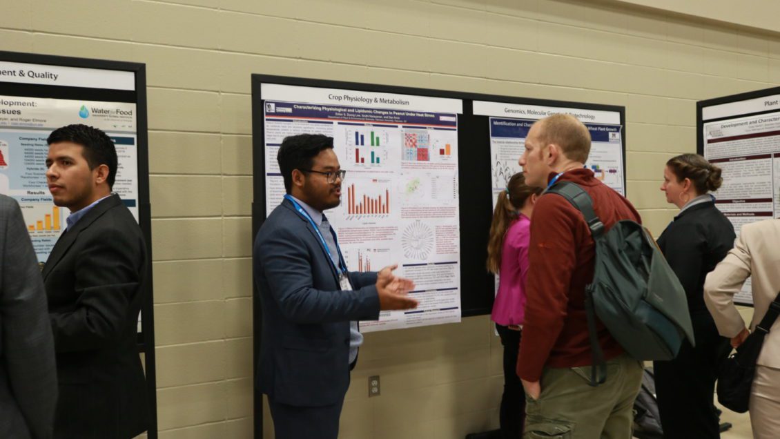 Zolian Zoong Lwe presenting his research to visitors at the international crop science meeting.