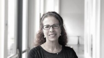 Photo of woman standing in a hallway with windows