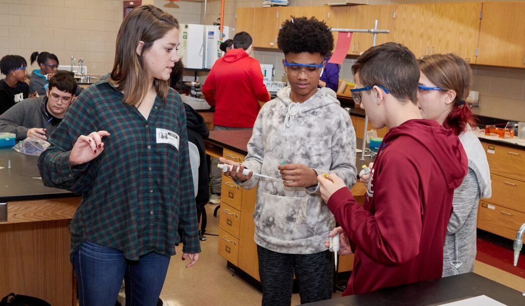 Shealy with high school students holding pipettes