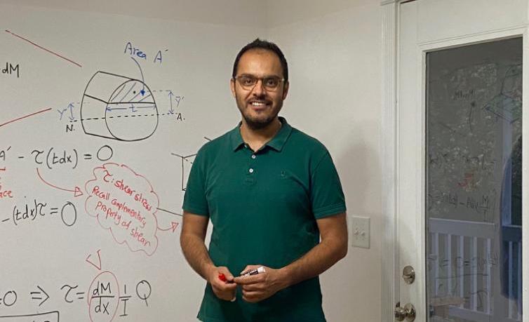 Fadi Abdeljawad stands in front of the wall he converted into a whiteboard.