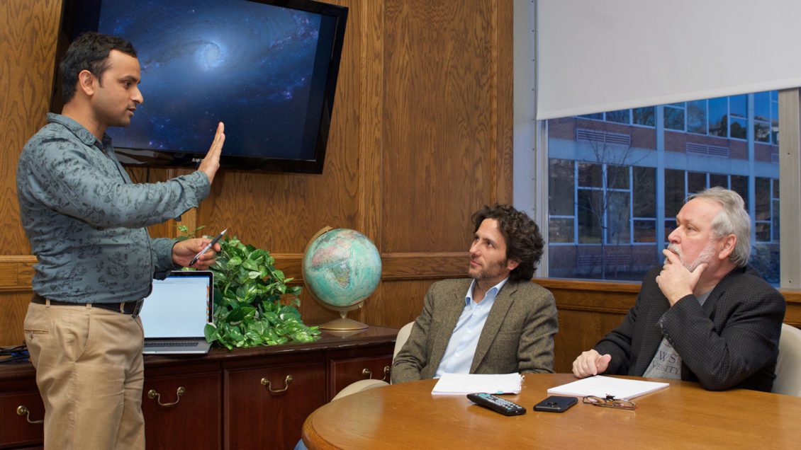 Three researchers talking in conf room