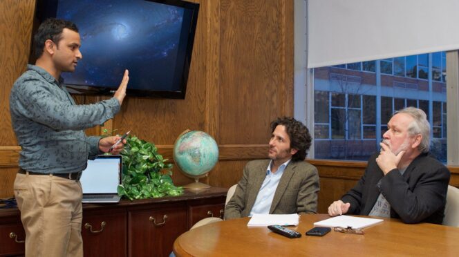 Three researchers talking in conf room