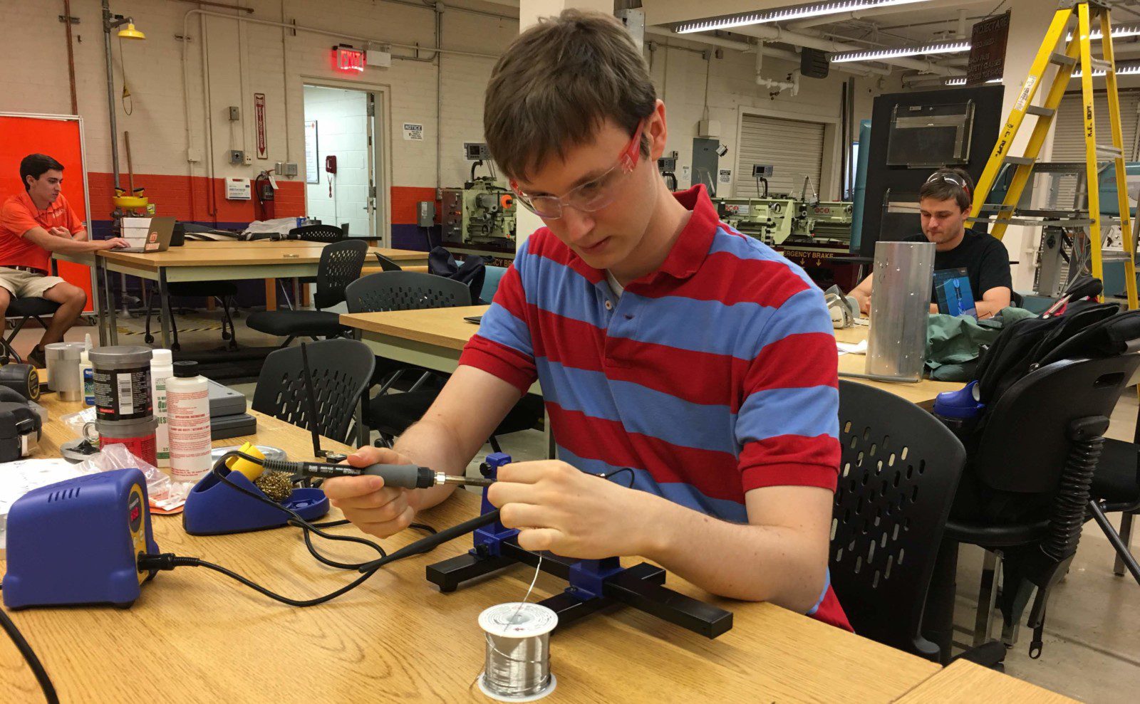 Charles Dove solders a circuit board as part of his work with the Rocket Engineering Team.