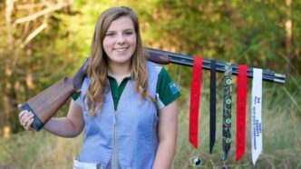 Tatelyn Benton poses with her shooting medals and shotgun.
