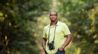 Drew Lanham poses with binoculars while birding.