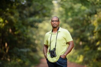 Drew Lanham poses with binoculars while birding.