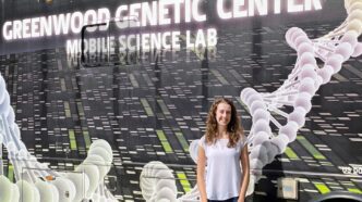 Rebecca MacPherson stands next to a van.