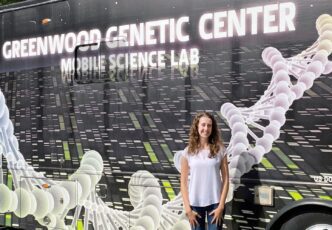 Rebecca MacPherson stands next to a van.