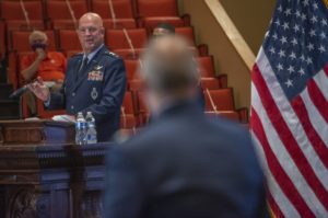 An Air Force general in dress uniform smiles as he addresses Col. Balts, whose back is turned toward the camera