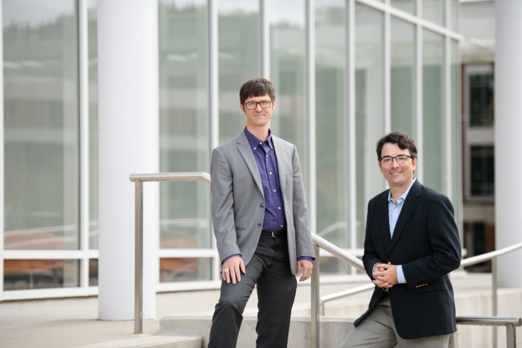 Darren and Patrick stand outside on the stairs of the University's Watt Center.
