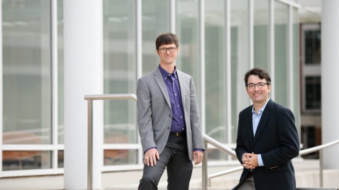 Darren and Patrick stand outside on the stairs of the University's Watt Center.